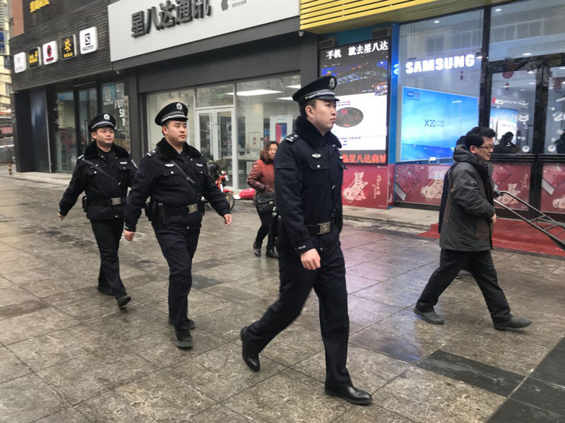 王帅（中）和自己的同事在辖区内的商业街巡逻