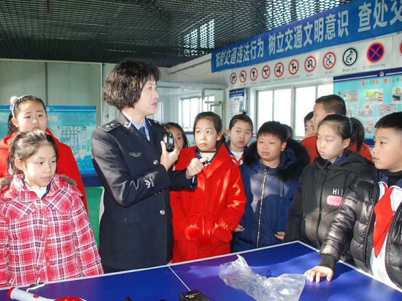 图三民警向学生们展示讲解了执法记录仪、酒精检测仪、警务通等执法装备使用