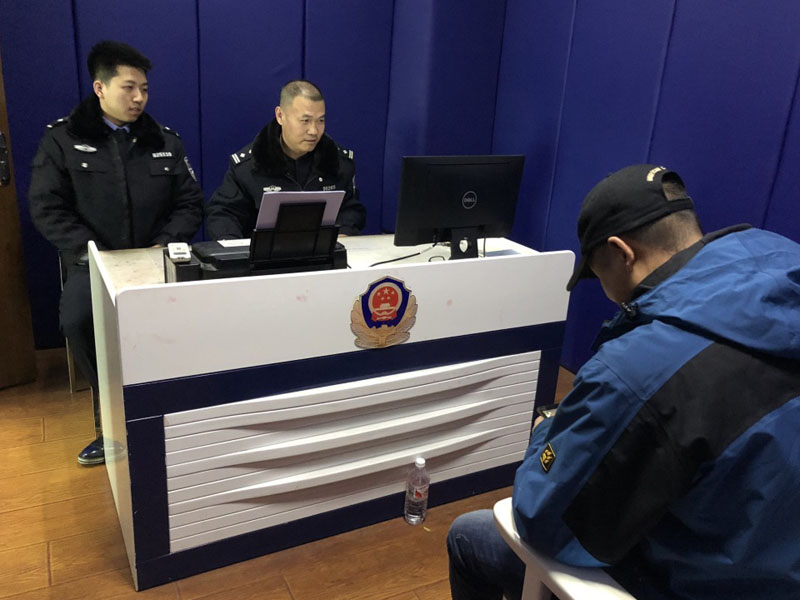 图十三 刘继红（中）为报案人做笔录