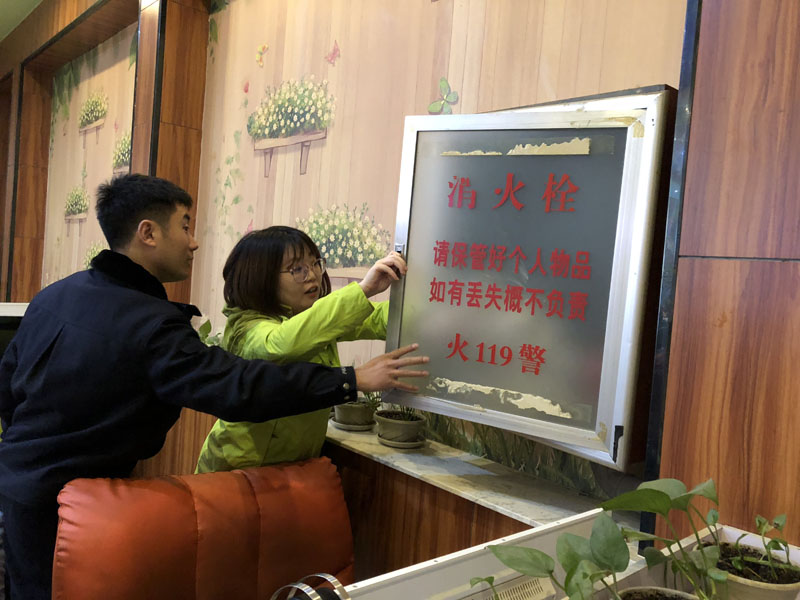 （图三）民警指导记者检查网吧消防栓