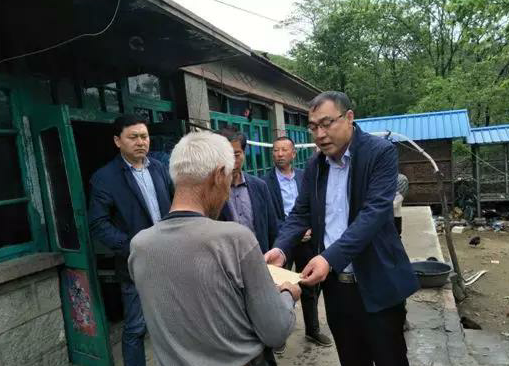 金龙（右一）探望贫困村民