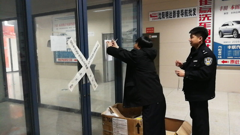 法官带领法警正在给所腾房屋贴封条