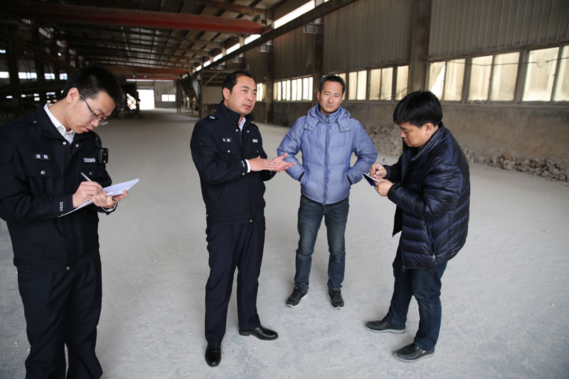 闫永刚（左二）在案件现场勘查后向记者介绍情况