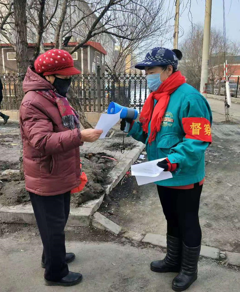 陈颖（右）在向社区居民发放宣传单