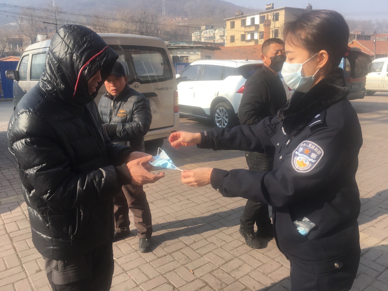 蔡冲将自费买的口罩递给群众并说教
