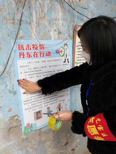 志愿者张贴抗击疫情海报