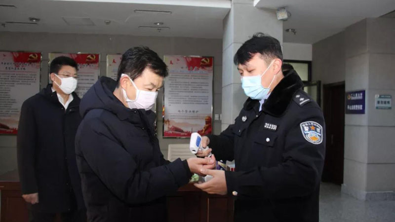 张学群（中）在本溪市平山区人民法院接受体温测量
