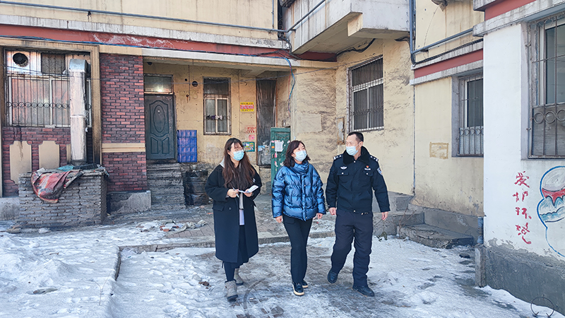 记者（左）正在和李广奇（右）、社区书记单麒（中）一起在社区走访
