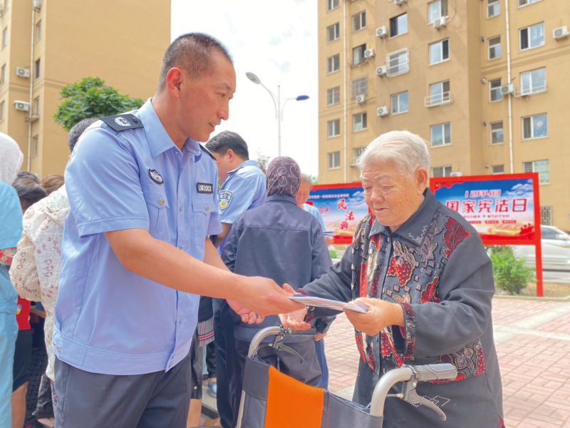 唐兵向孙秀梅老人发法治宣传手册1