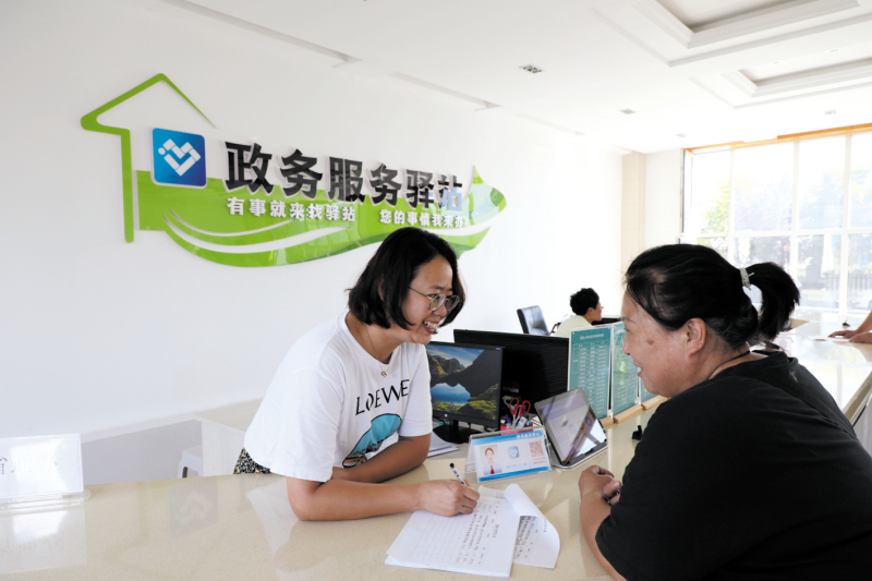 配文2：8月17日，左鑫（左）为刘淑洁办理业务中。