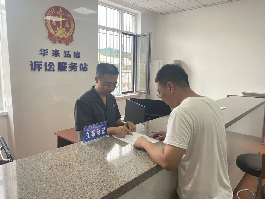 华来人民法庭诉讼服务站的工作人员指导当事人写起诉状。