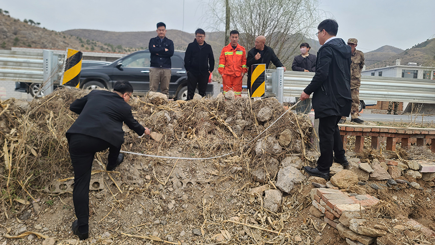 执行干警现场丈量石墙占道面积。
