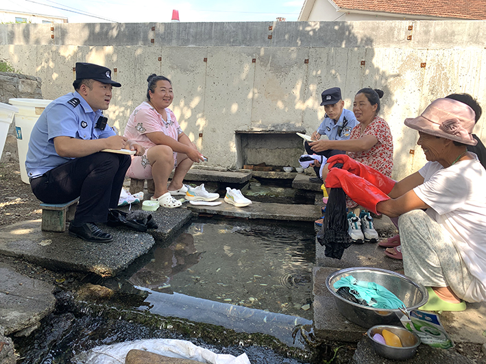 民警和村民在清泉边畅聊