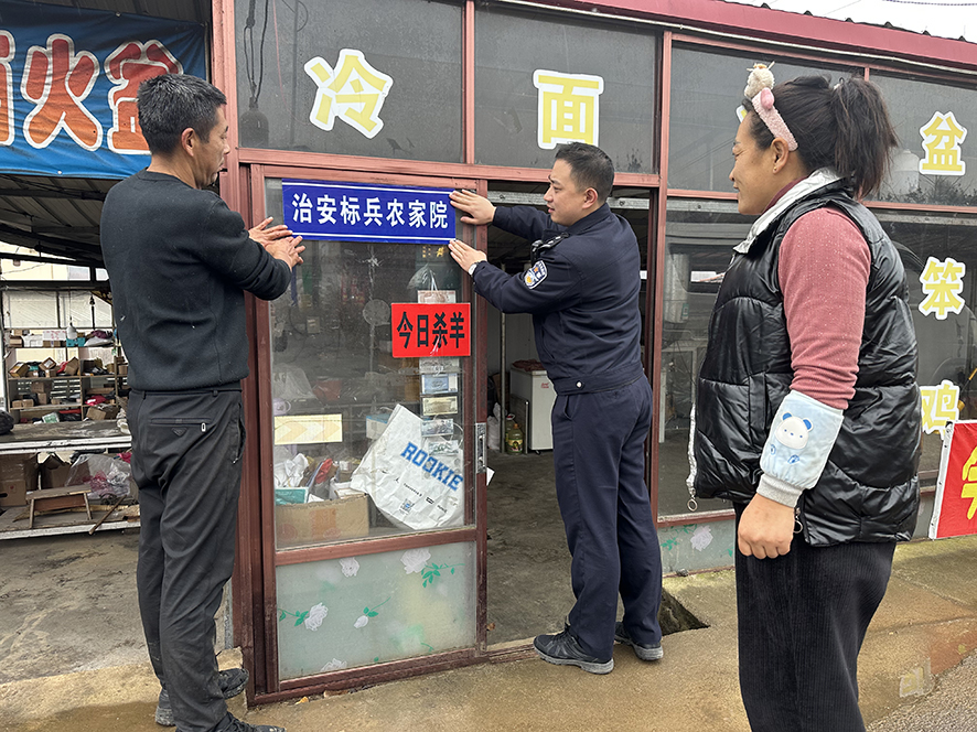 农家院老板管立法（左）将“治安标兵农家院”牌匾挂在最显眼的位置