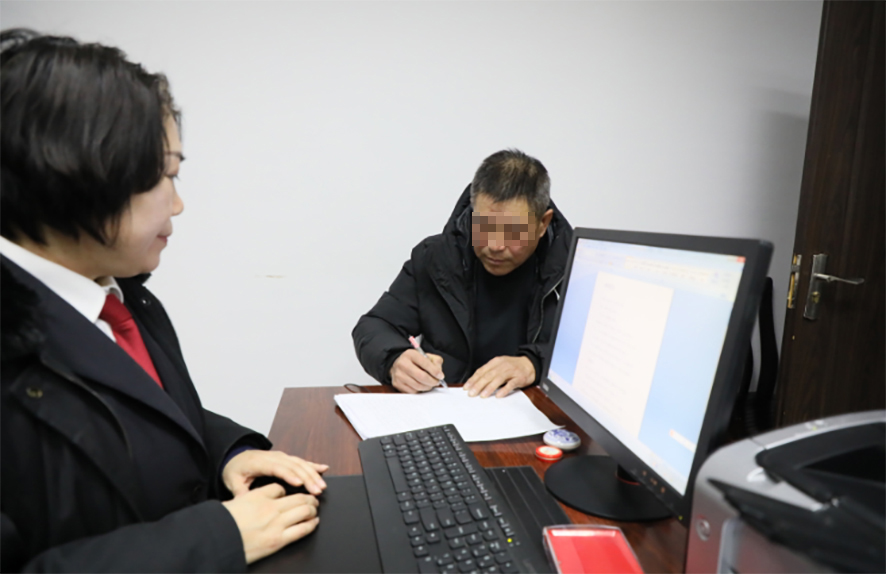 郭某（右）在履行承诺书上签字