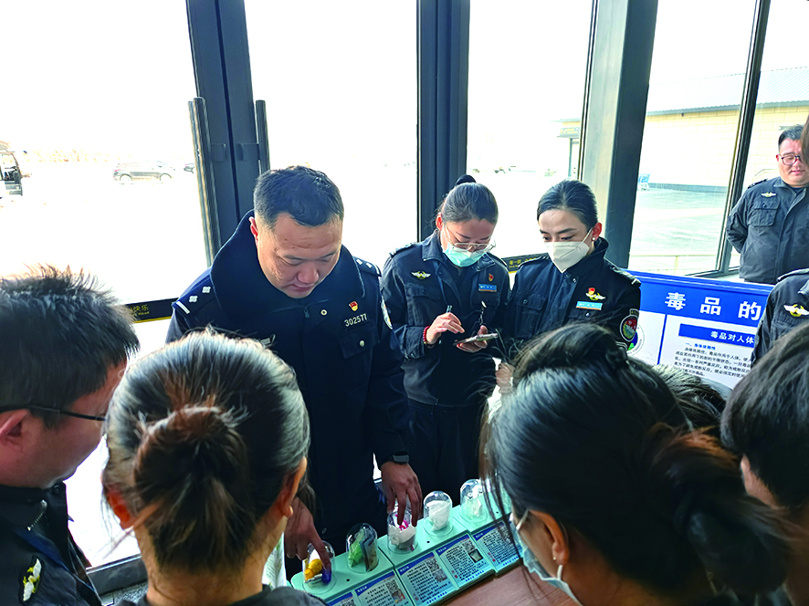 支队民警为通过仿真毒品为机场安检人员讲解毒品识别
