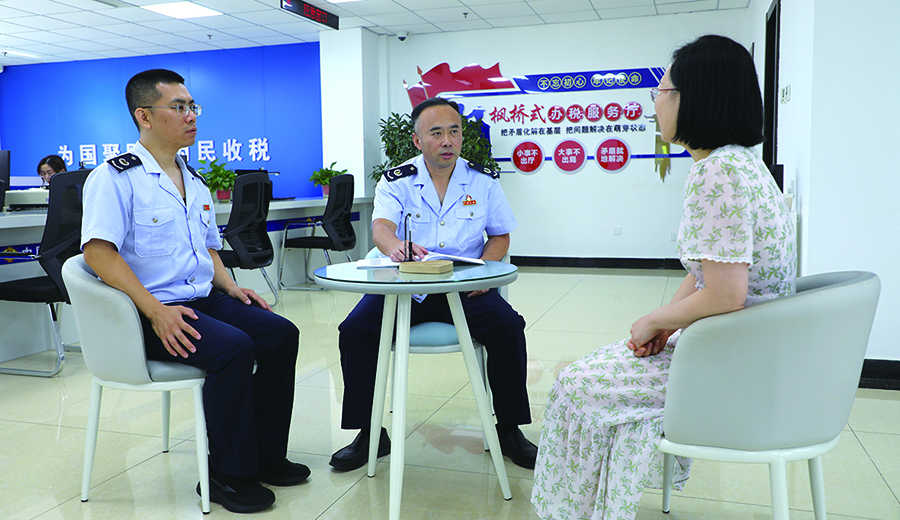 国家税务总局阜新市海州区税务局副局长李宁（中）为纳税人缴费人宣传社保费征缴相关政策。孟令冉 摄