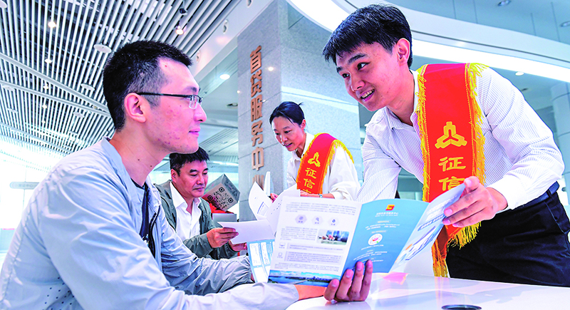 征信志愿服务大队志愿者在首贷服务中心为前来咨询征信业务的群众进行业务讲解