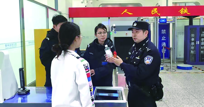 二题图,童秋华(右)在向旅客讲解安检规定