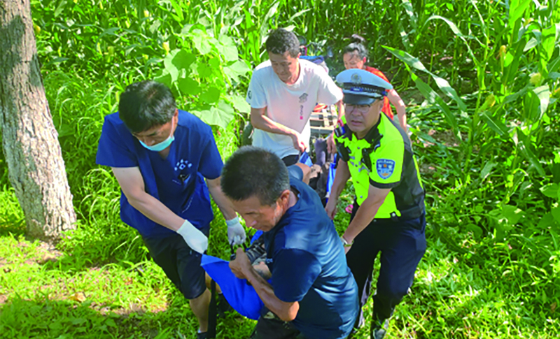 二题图，民警配合医护人员将受伤的驾驶人抬上救护车。