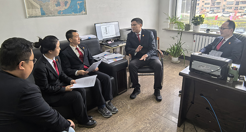 头题图，佟飞（右二）与执行干警研讨执行攻坚方案