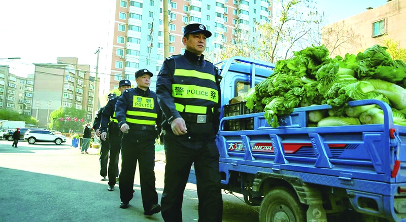 二题图,民警在秋菜售卖摊位集中区域开展巡逻