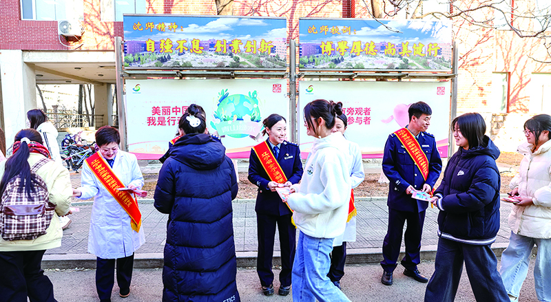 头题图,戒毒干警在沈阳师范大学校园发放宣传单。