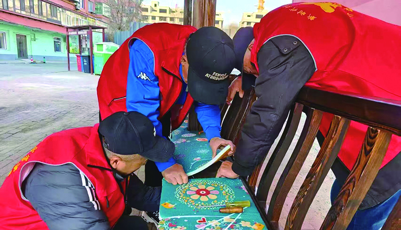 二题图,社区志愿者为连廊座椅加铺软垫
