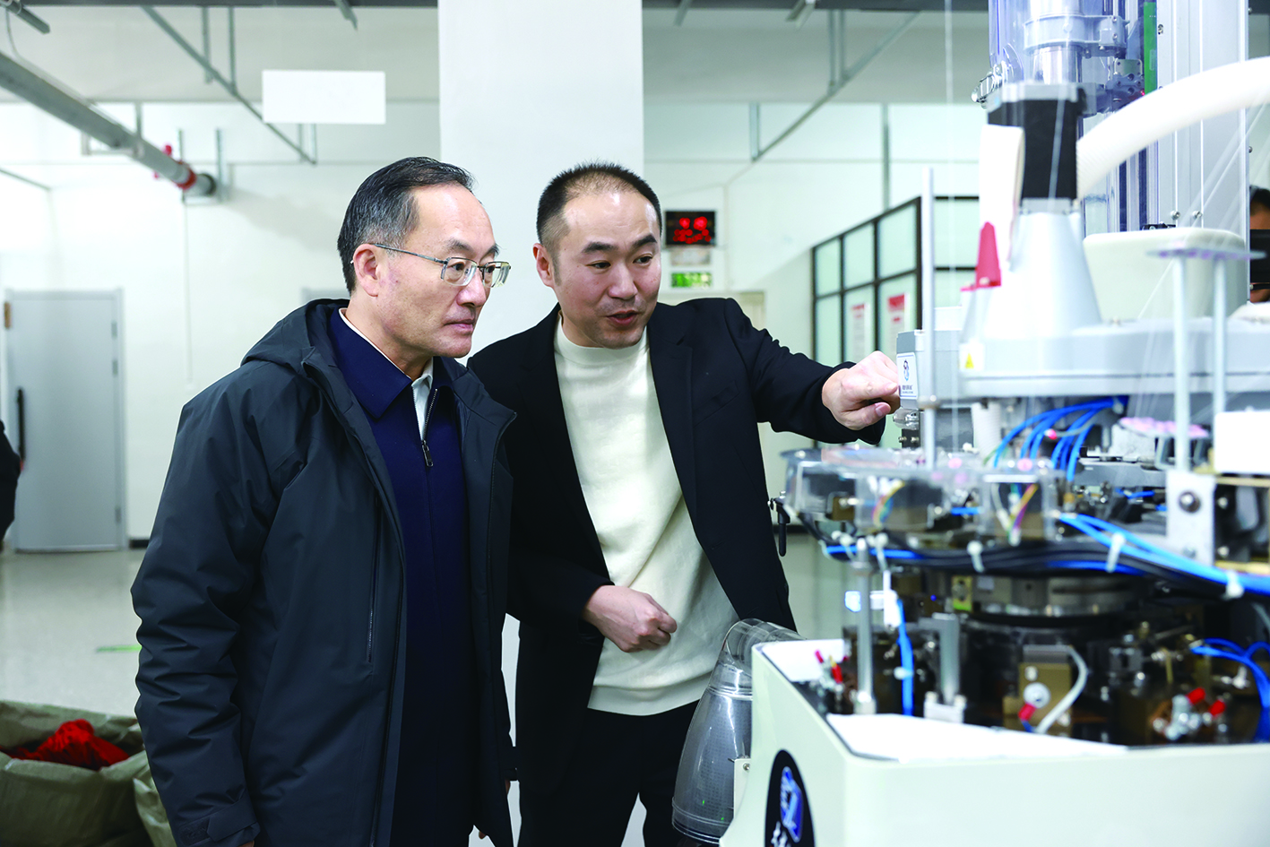 省委常委、政法委书记郑艺(左)在辽宁保利袜业进出口有限公司详细了解企业生产经营情况