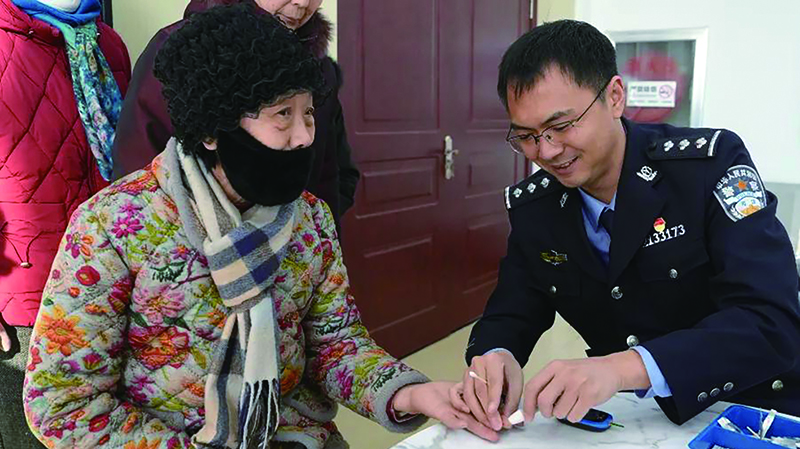 二题图，监狱医疗民警为村民们测量血糖。